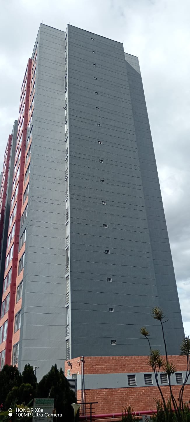 Torre terminada en acabado gris, vista desde el acceso vehicular