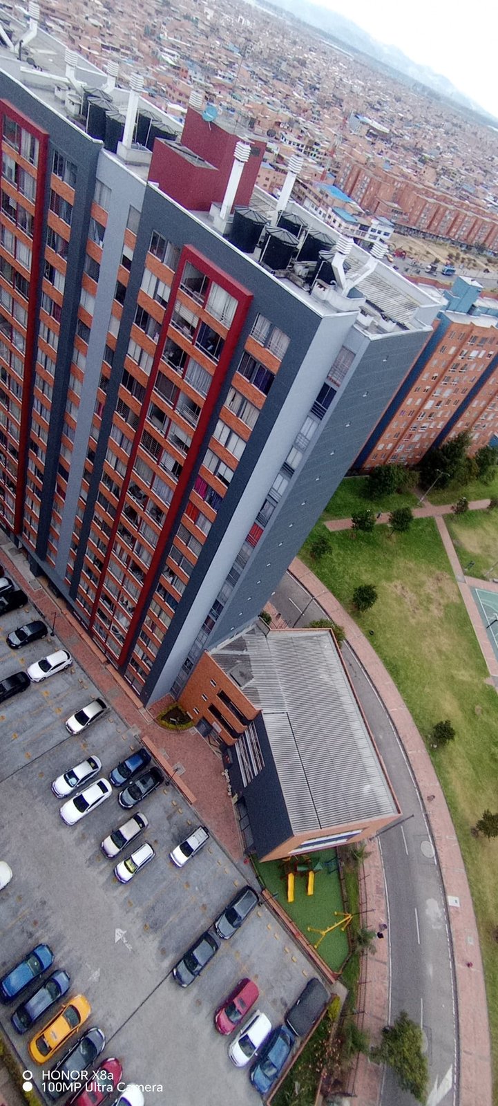 Torre terminada en gris con el perfil urbano de Bogotá al fondo