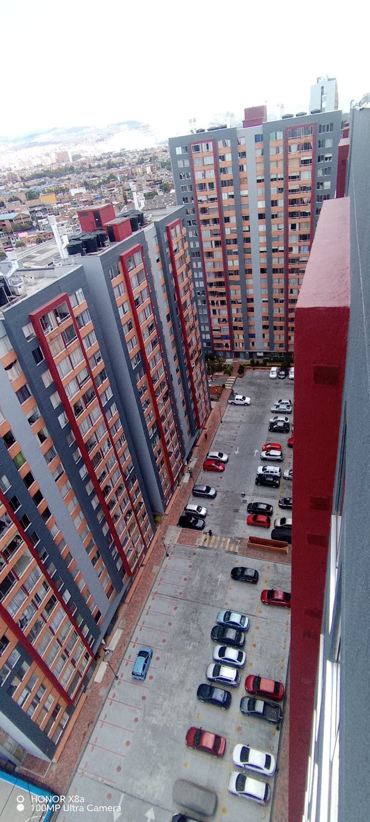 Torres con acabado mixto, gris y ladrillo, vía interna de por medio