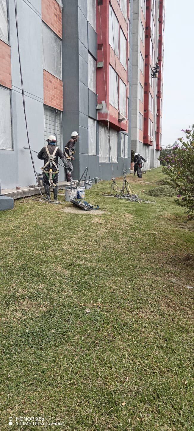 Cuadrilla trabajando sobre la fachada vista desde la zona verde