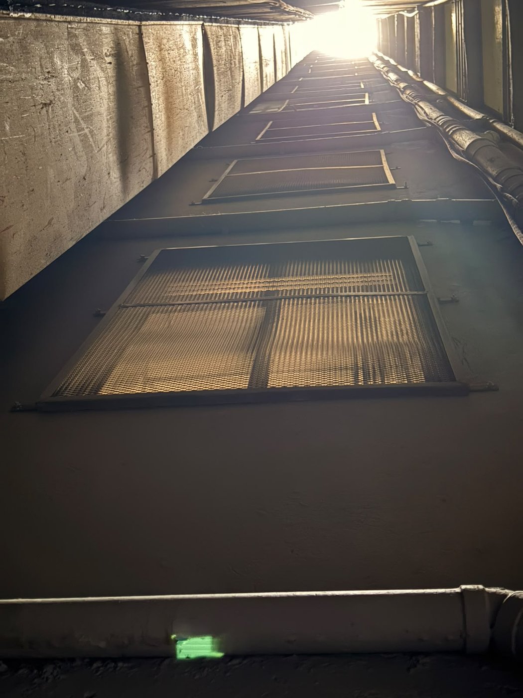 Ducto visto hacia arriba con las rejillas instaladas dejando pasar la luz