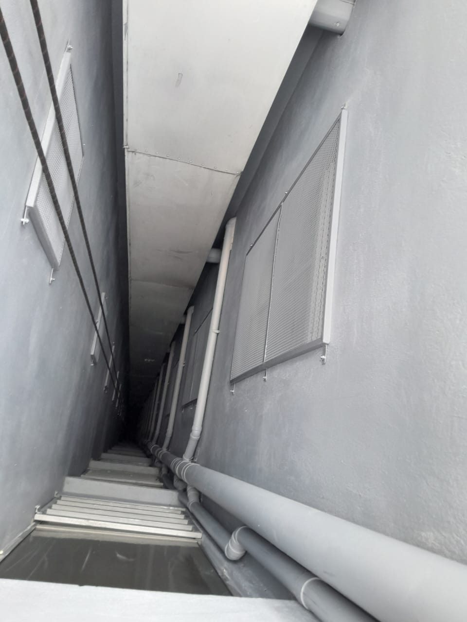 Dos rejillas instaladas en el muro del ducto, con las cuerdas de acceso a la izquierda