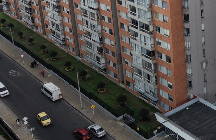Reja perimetral y portón del conjunto Prado Verde frente a las torres, vista desde el dron