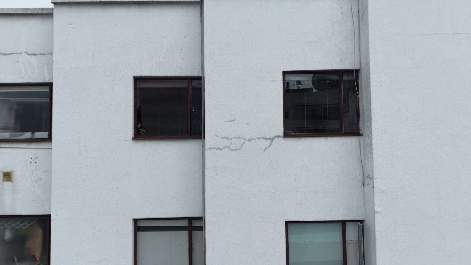 Paño de fachada del Edificio XUE con fisuración vertical junto a la ventanería
